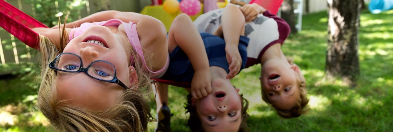 Child wearing glasses in hammock.